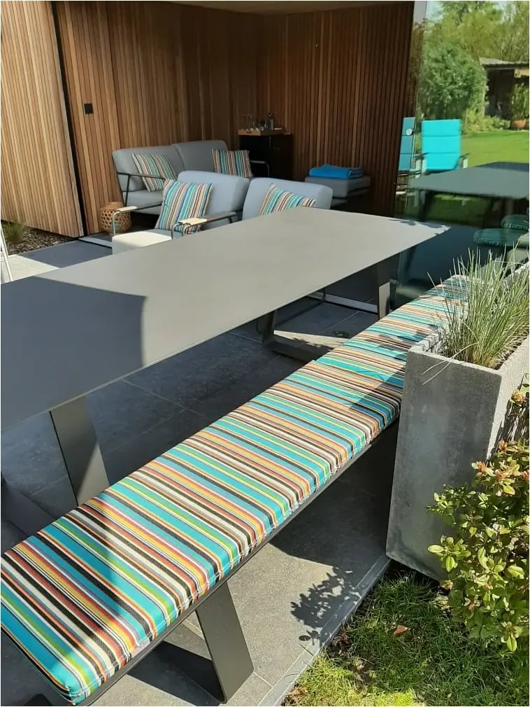 En skræddersyet picnicbænkpude med forskellige farverige striber. En ideel udendørspude.