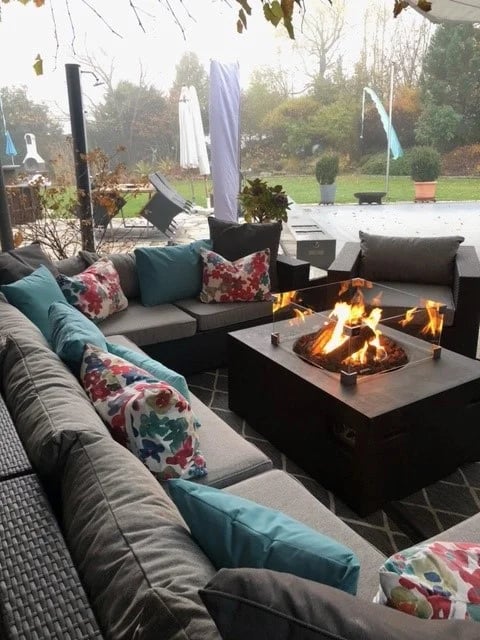 Un conjunto de jardín con cojines de salón a medida en gris, con cojines decorativos en azul claro.