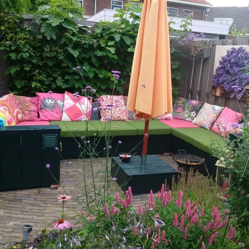 Un conjunto de jardín con cojines de salón a medida en color verde y rosa.