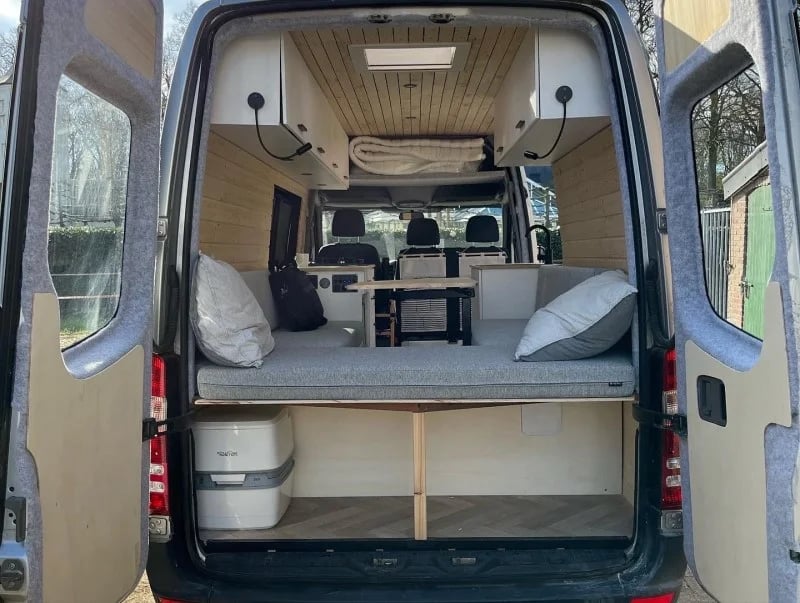 Un coin salon sur mesure avec des coussins de caravane gris clair.