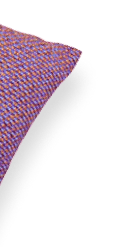 Un coin d'un coussin décoratif violet avec un motif rayé.